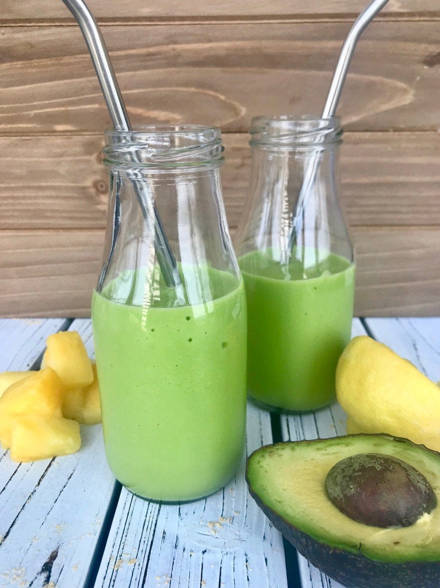 Two small glasses of a green avocado smoothie.