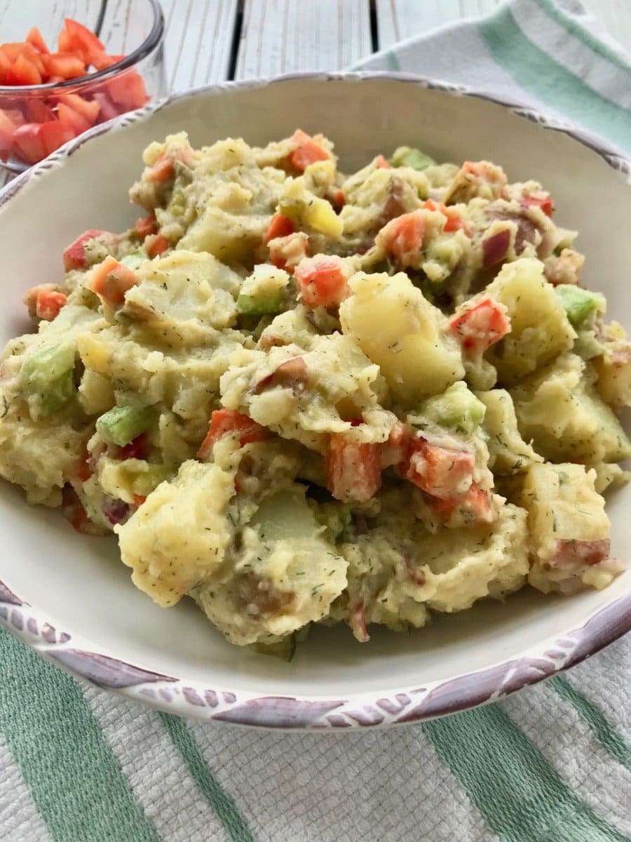 Creamy potato salad with vegetables in a bowl.