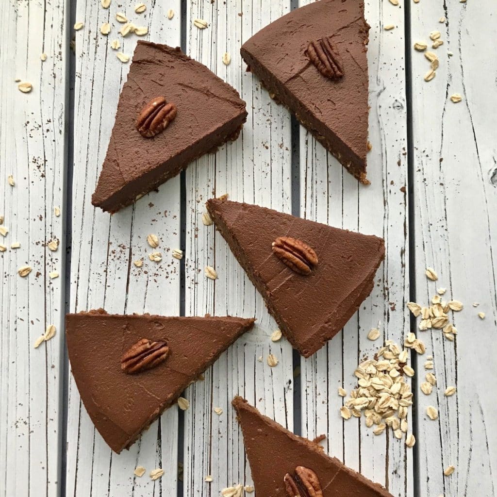 Slices of chocolate sweet potato pie with pecans on top of each slice.