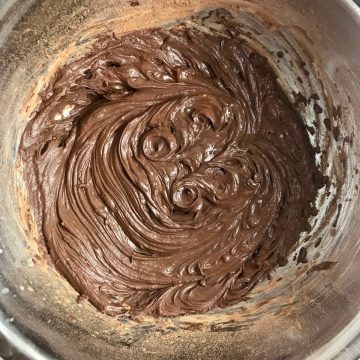 Vegan chocolate frosting in a bowl after being whipped.