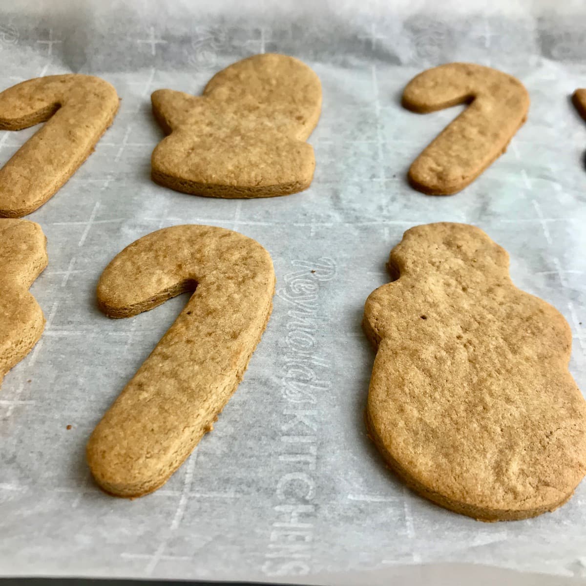 Close-up of Christmas-shaped coconut sugar cookies on a baking tray. 