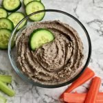 Black bean hummus with cucumbers and carrots on the table.