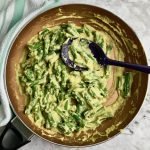 Vegan green beans in a pan with a serving spoon.