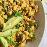 Half a bowl of tofu scramble with avocado slices and text that says, "Tofu Scramble Easy vegan breakfast recipe."