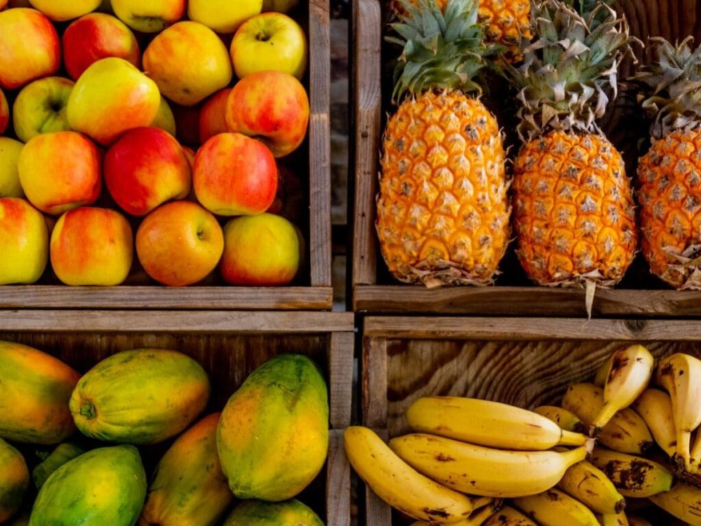 4 boxes, containing apples, pineapples, mangoes, and bananas.