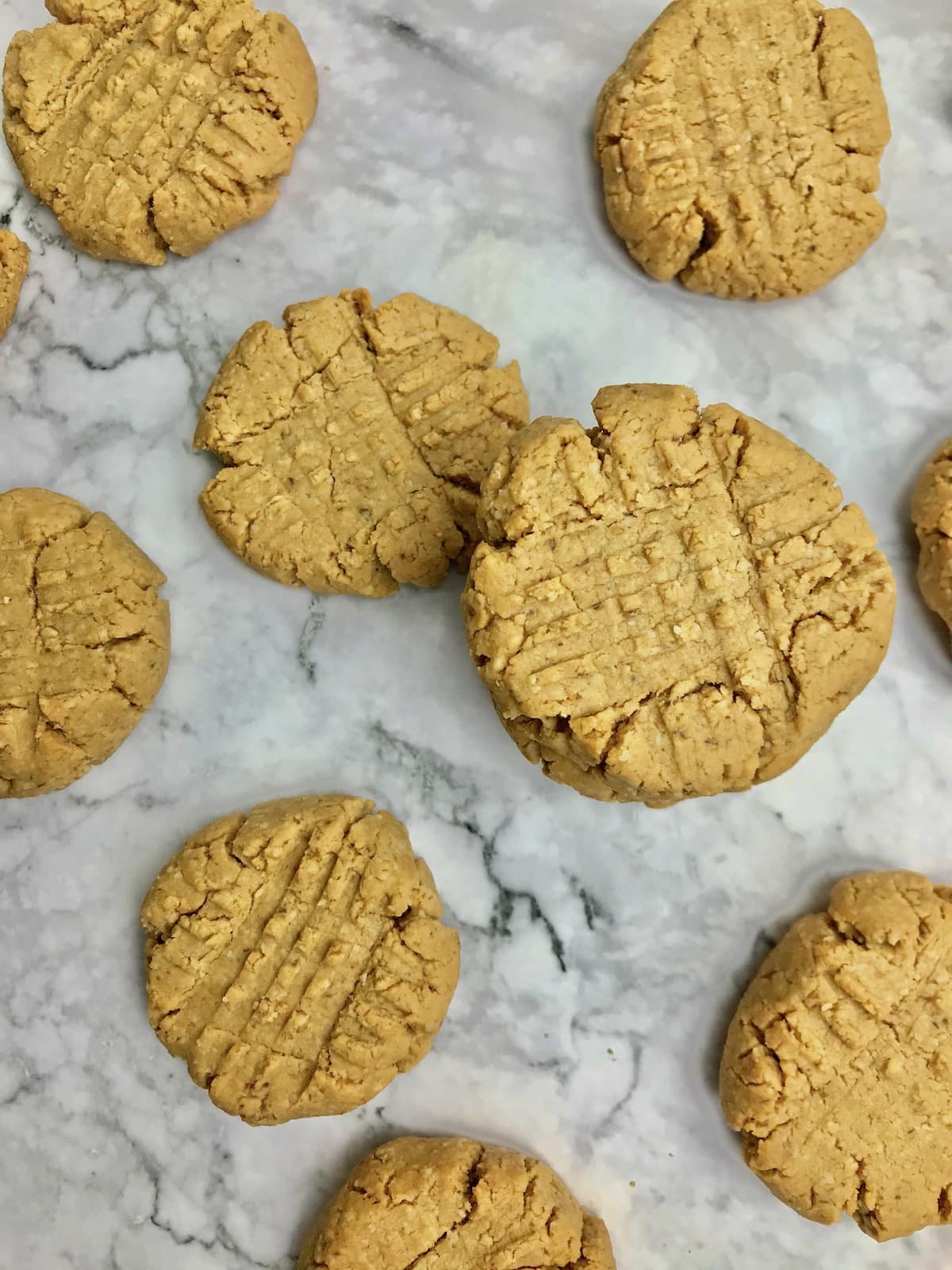 Peanut butter cookies scattered on a marble table. 