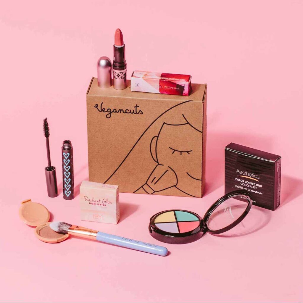 A cardboard box surrounded by makeup products.