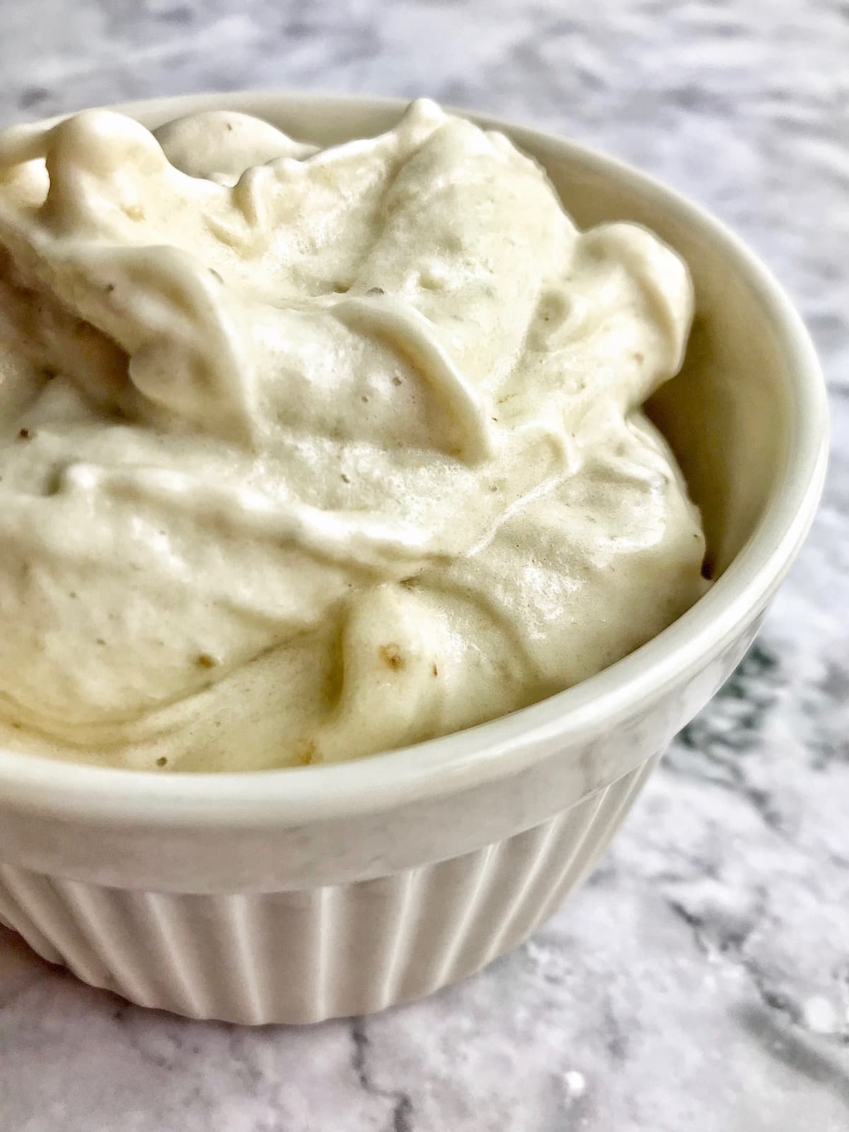 Frozen blended bananas in a white dish.