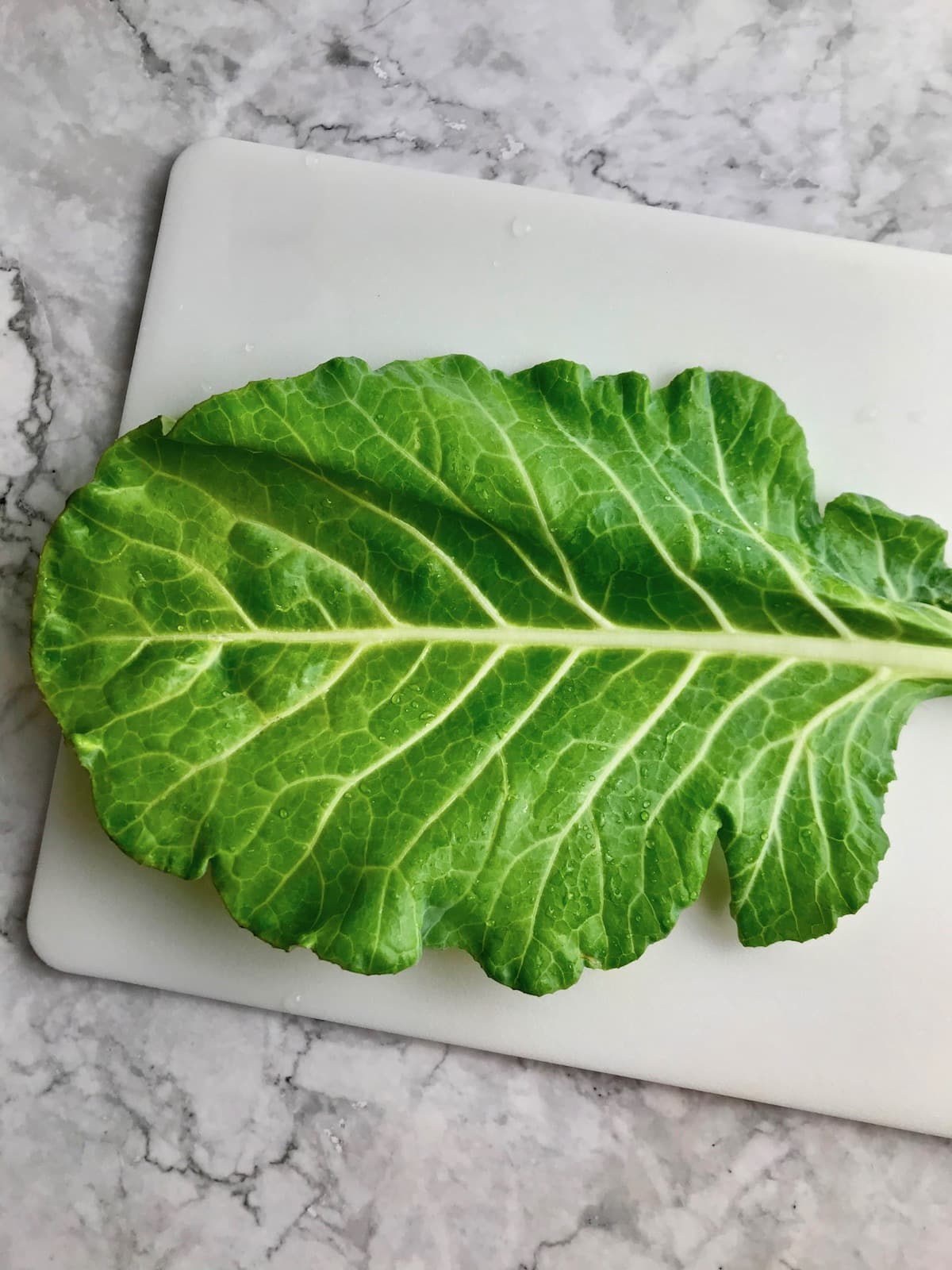 A collard leaf on a cutting board.