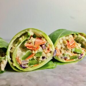 A cut collard wrap showing the quinoa and vegetable filling inside.