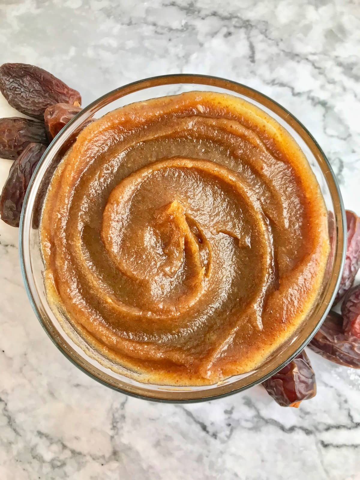 Vegan caramel dip surrounded by Medjool dates.