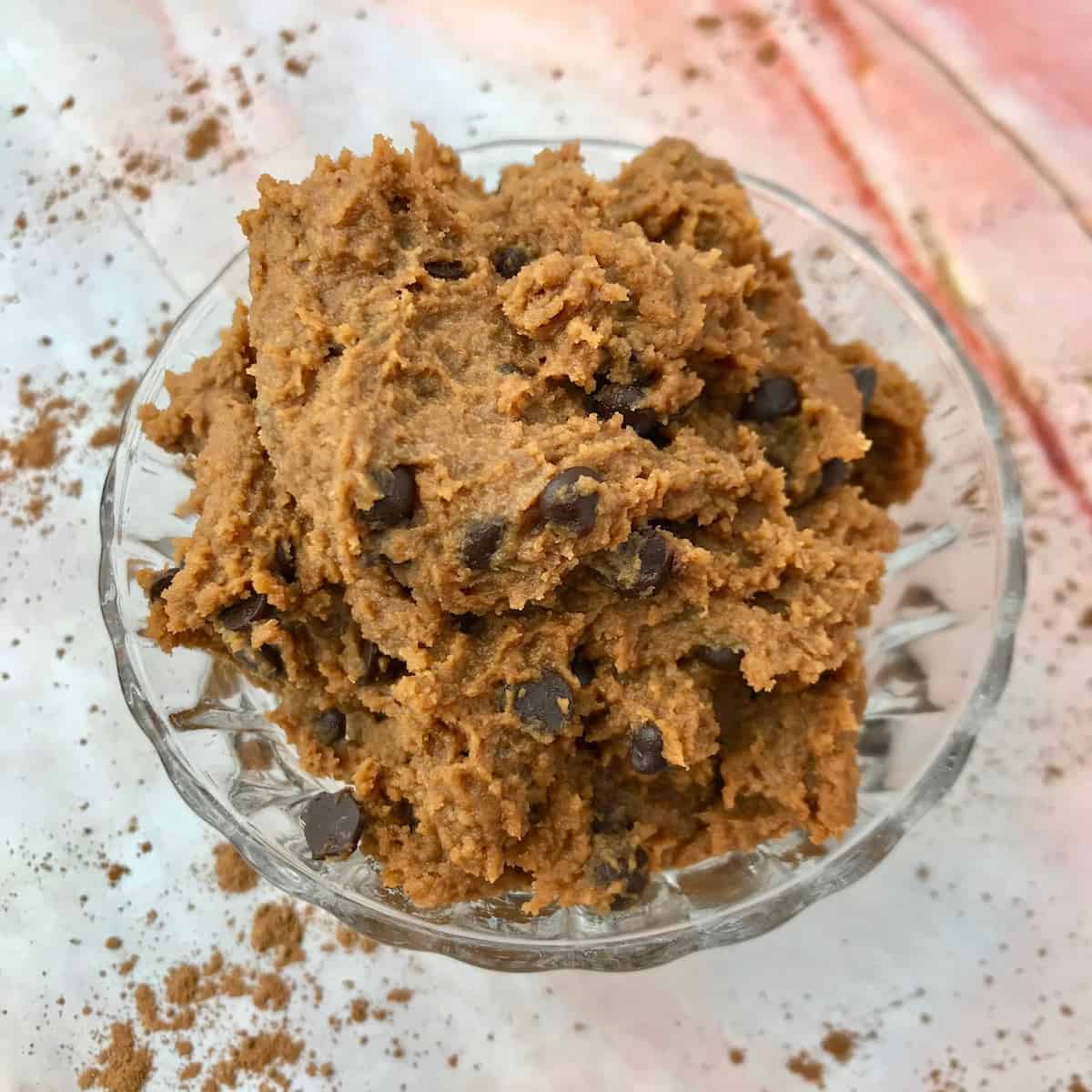 Chickpea cookie dough mixed with chocolate chips in a glass bowl.