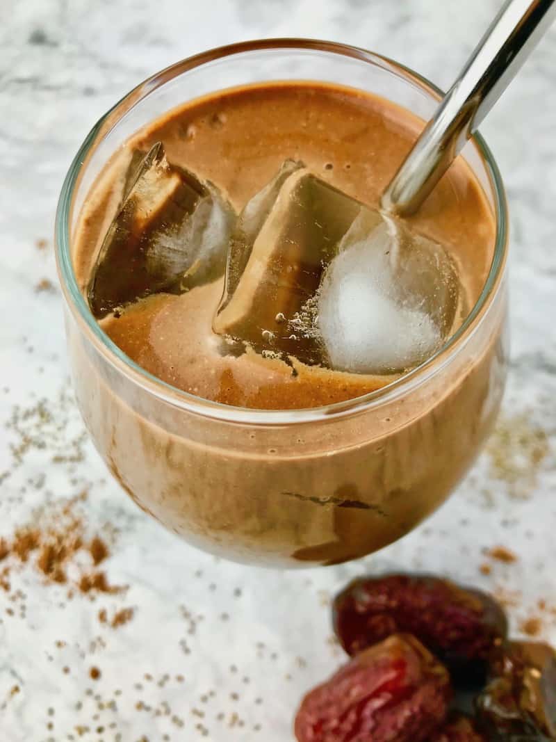 A coffee smoothie with ice in a stemless wine glass.