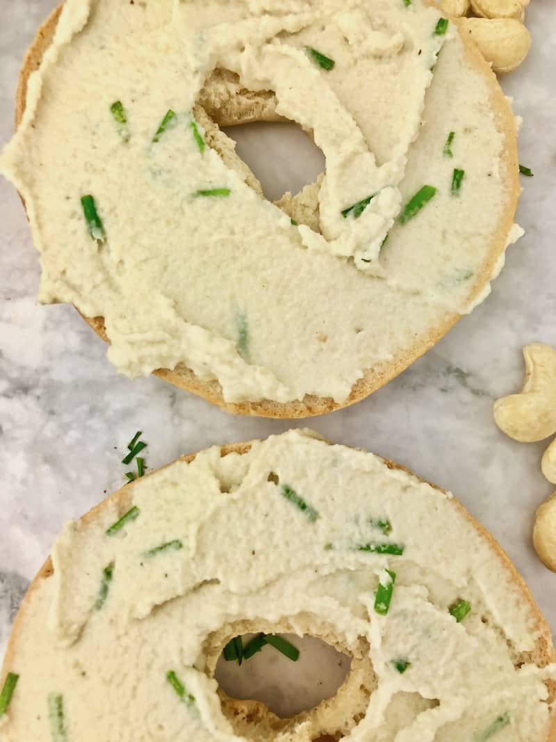 Two bagel halves with cashew cream cheese spread on them.