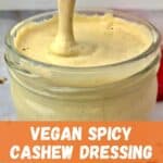Creamy dressing pouring into a jar, with text that says, "Vegan Spicy Cashew Dressing."