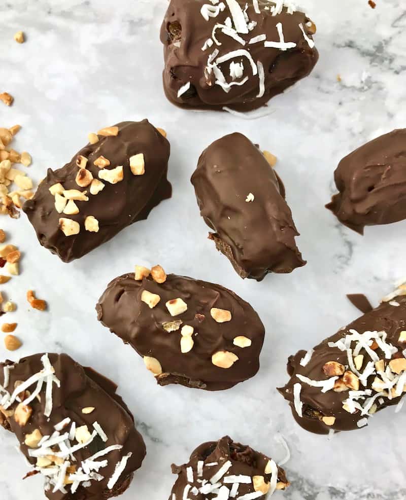 Hardened chocolate dates, some with chopped peanuts and coconut flakes on top.