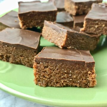 Several chocolate almond butter bars on a green plate.