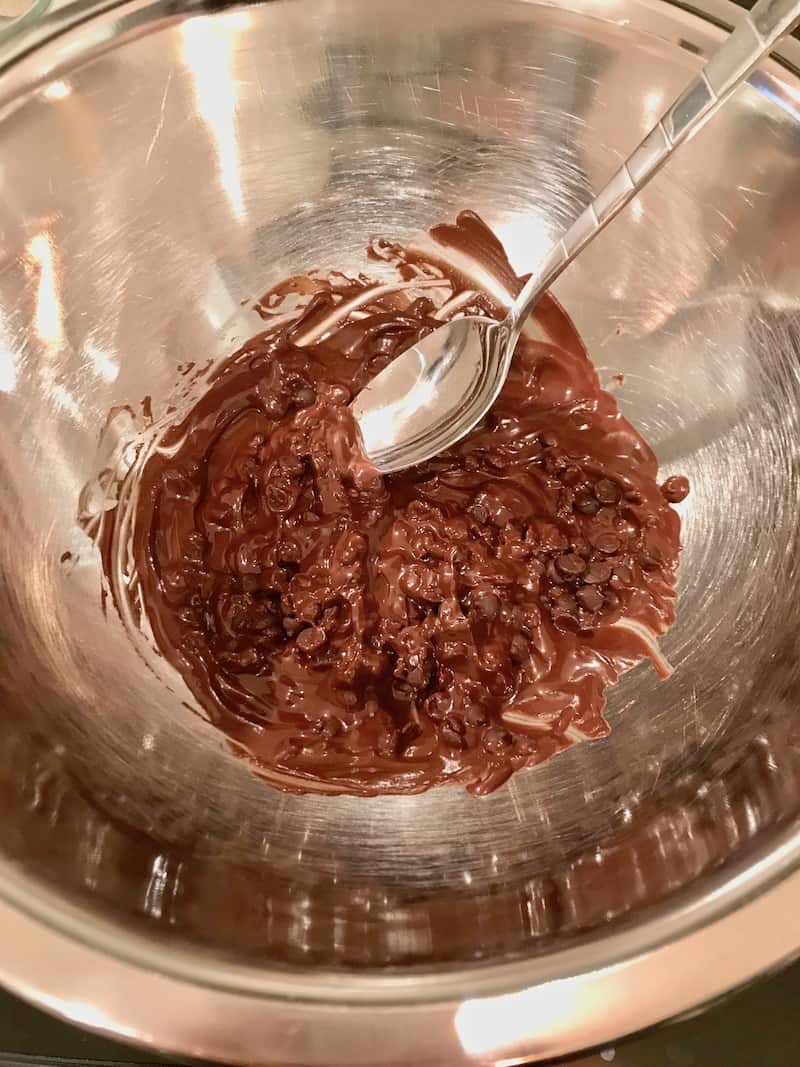 Melted chocolate chips in a bowl with a spoon.