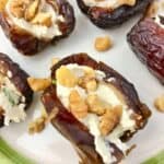 Dates with cream cheese and walnut pieces on a green and white plate.