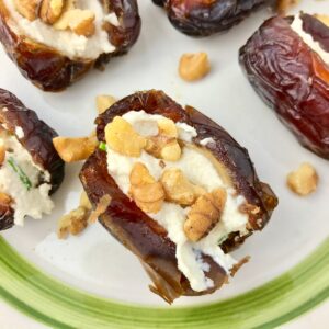 Dates stuffed with vegan cream cheese and chopped walnuts.