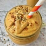 A sweet potato smoothie with peanut butter and hemp hearts on top.