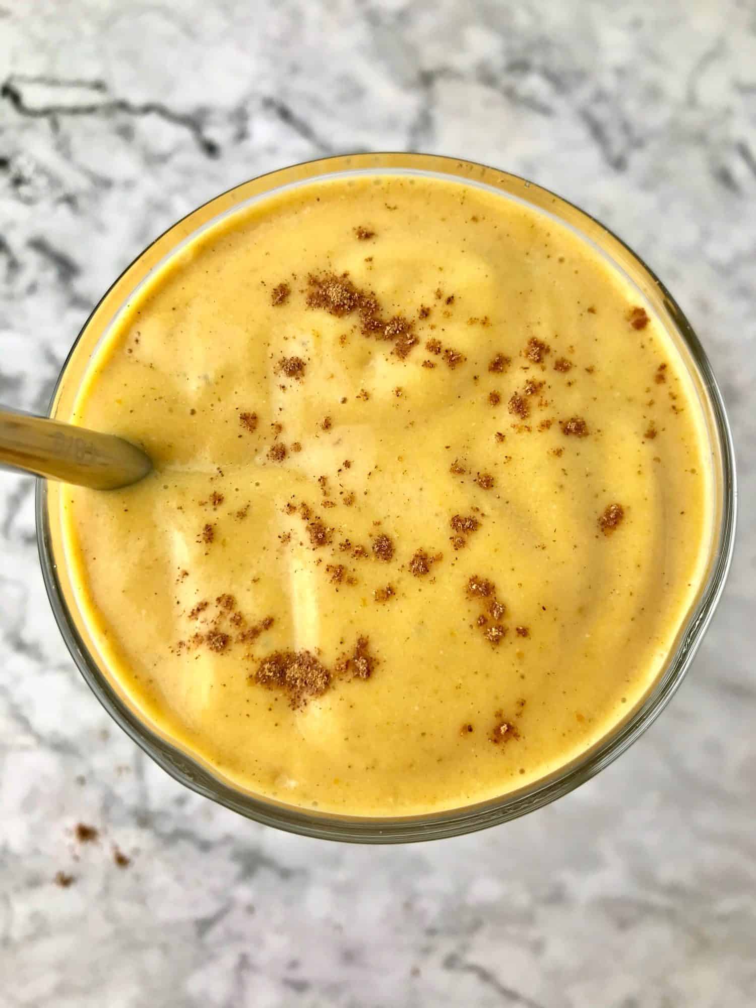 Overhead view of a sweet potato smoothie topped with pumpkin pie spice.