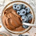 A small bowl of chocolate pudding topped with blueberries.