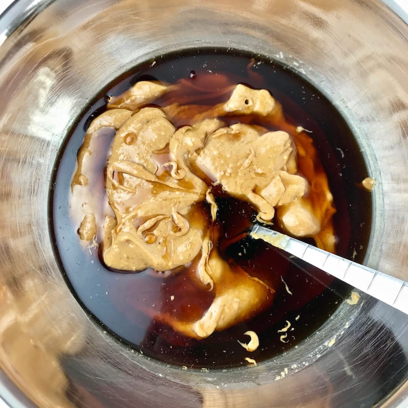 Peanut butter and maple syrup in a bowl with a spoon.