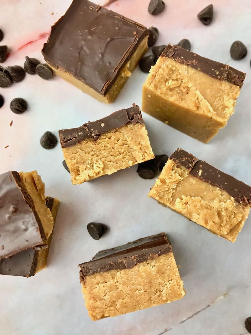 Chocolate peanut butter bars laid on their sides, next to chocolate chips.