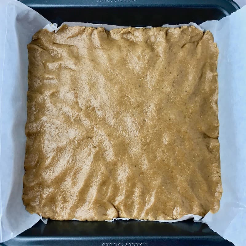 Peanut butter dough pressed into a baking dish.