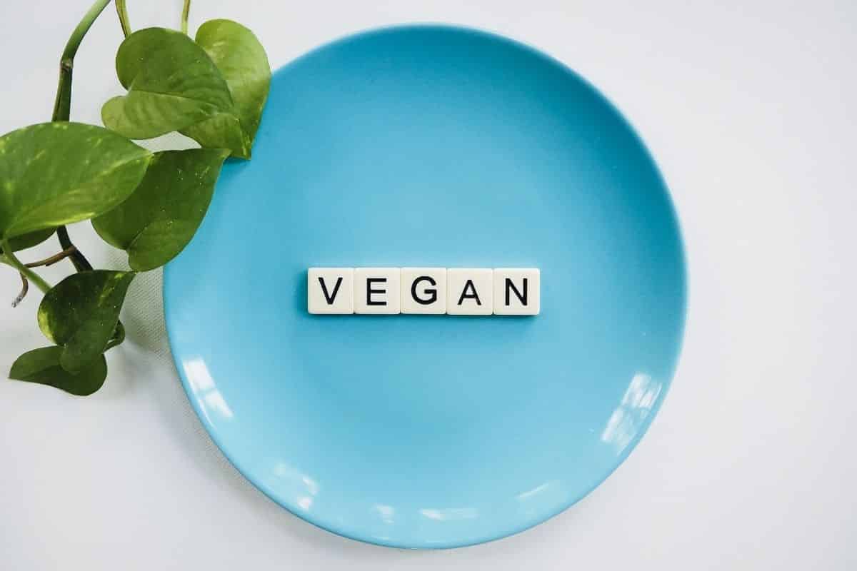Tiles that spell the word Vegan laid out on a blue plate.