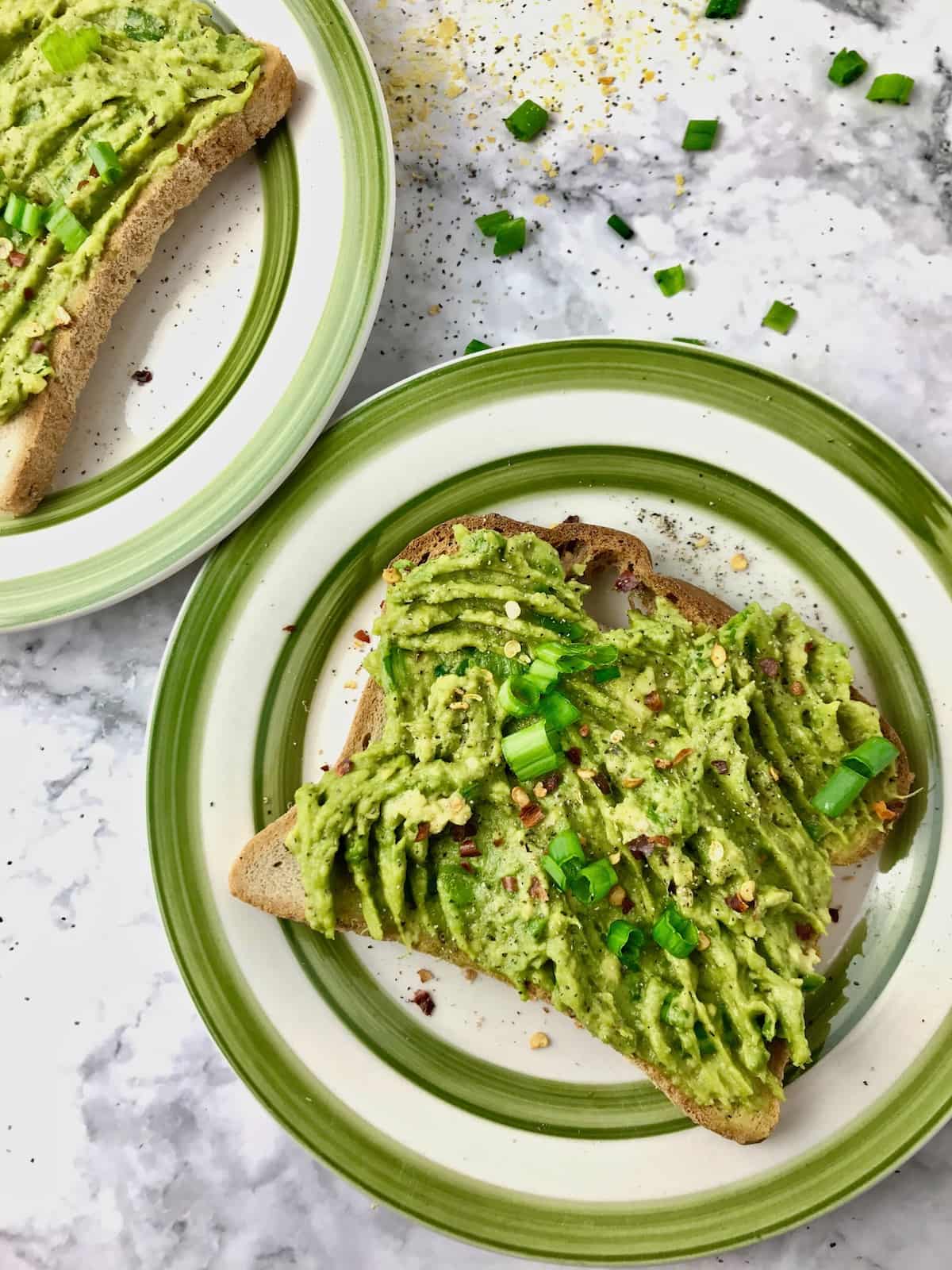 A piece of avocado toast on a plate.