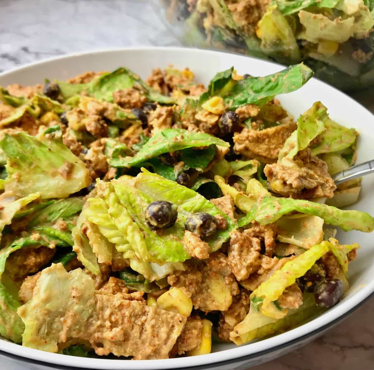 A bowl of taco salad with a creamy dressing.