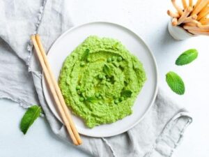 Green mint and pea dip on a plate.