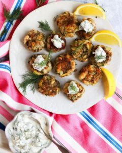 Vegan crabcakes on a plate with lemon wedges.