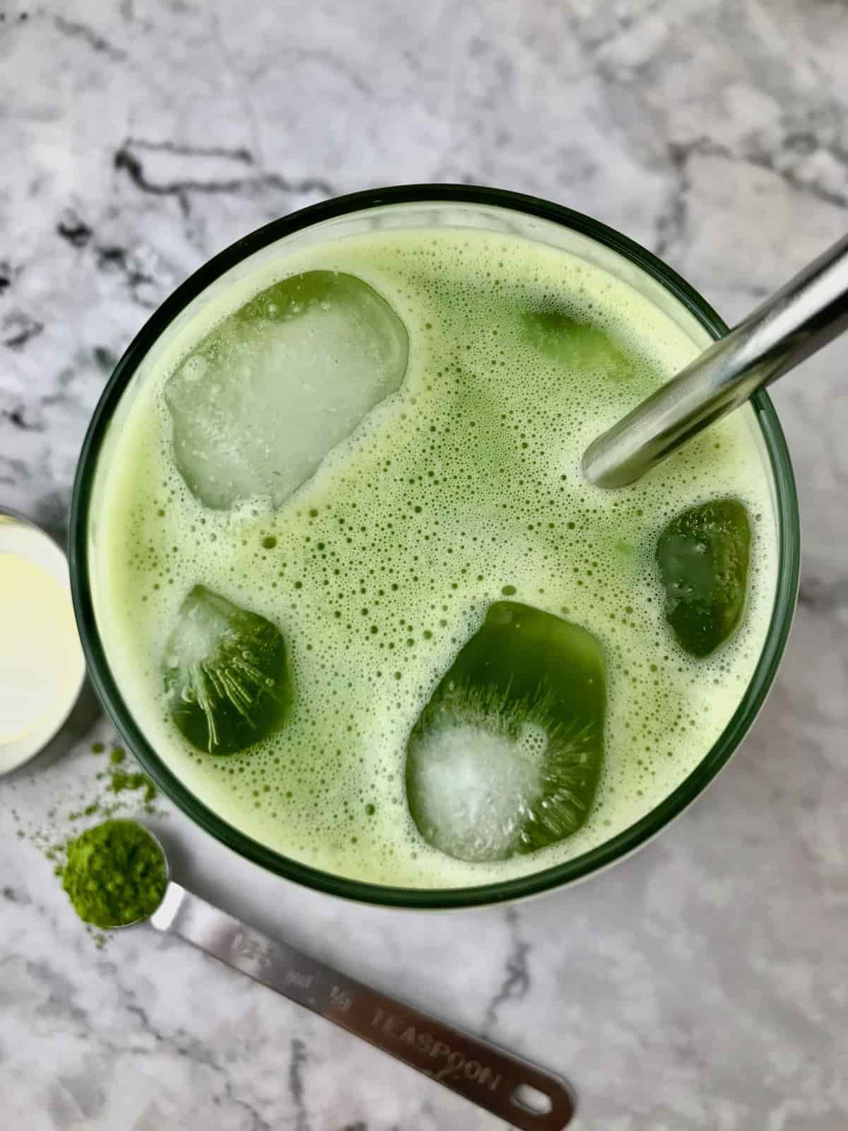 Overhead view of a glass filled with an iced matcha latte.