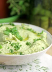 Avocado poblano dip topped with fresh herbs.