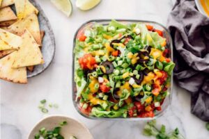 A 7 layer mexican dip next to chips.