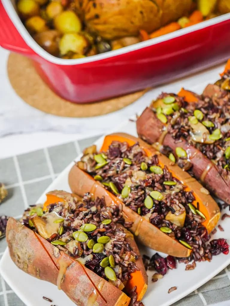 A row of sweet potatoes stuffed with rice, cranberries, and more.