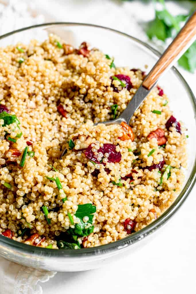 A bowl of quinoa salad with pecans and cranberries.