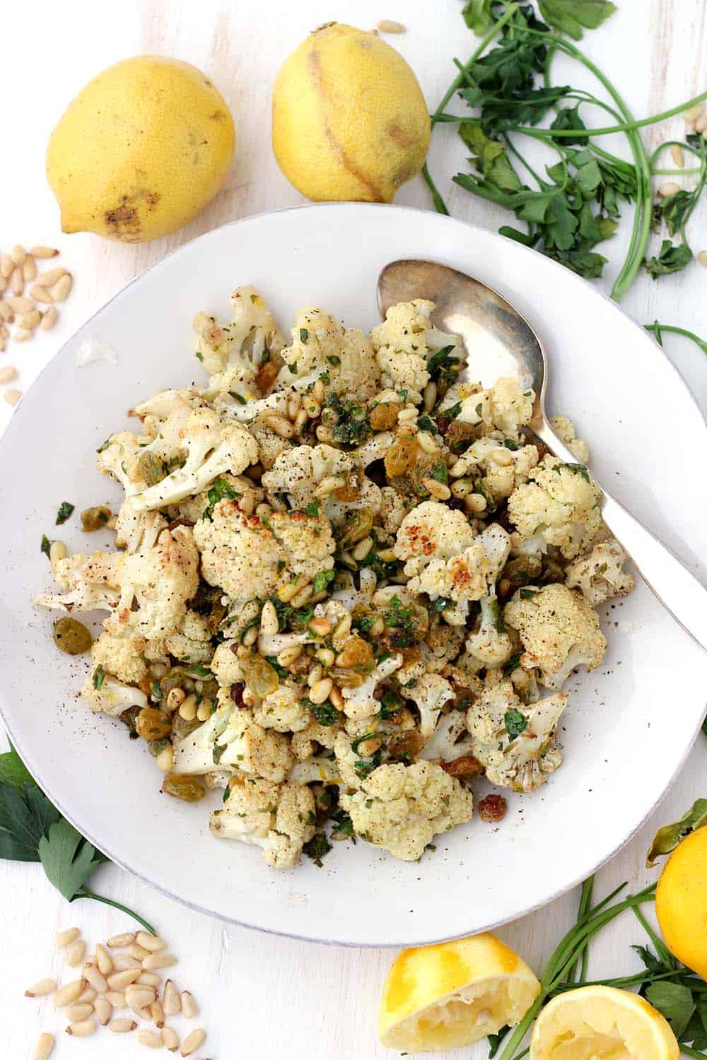 A bowl of roasted cauliflower with pine nuts and raisins.