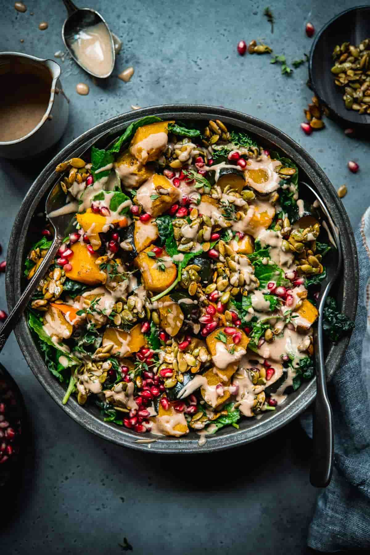 A bowl of acorn squash salad with pumpkin seeds and a creamy dressing.