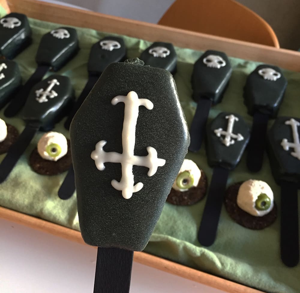 Coffin-shaped pumpkin cakes on popsicle sticks.