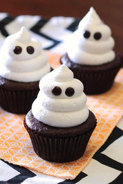 Chocolate cupcakes with white frosting and candy eyes.