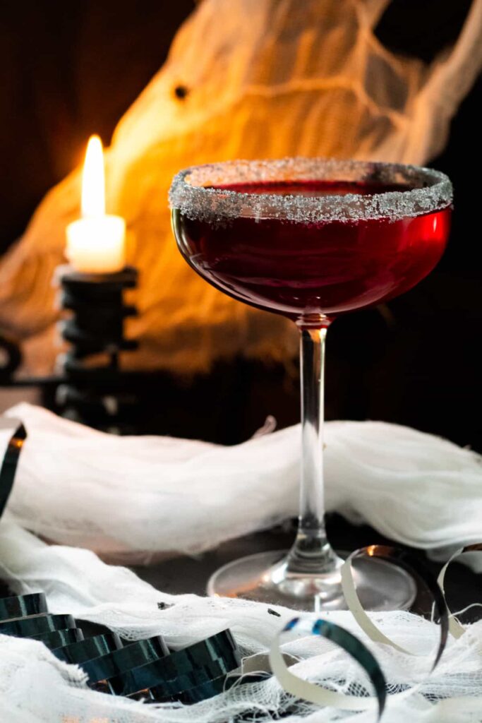 A red vampire-themed mocktail in a wine glass.