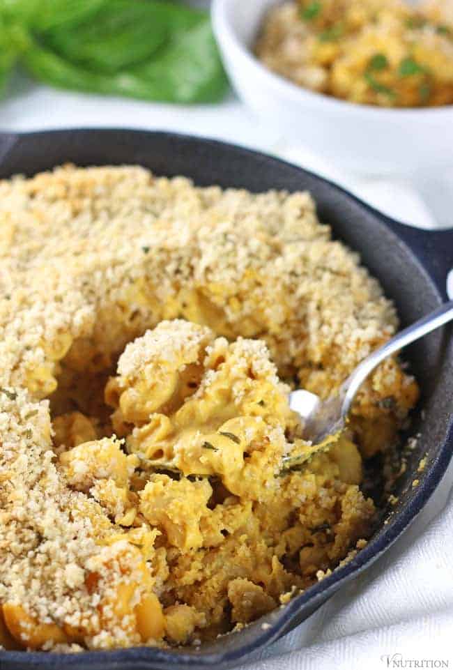 A bowl of vegan pumpkin mac and cheese topped with breadcrumbs.