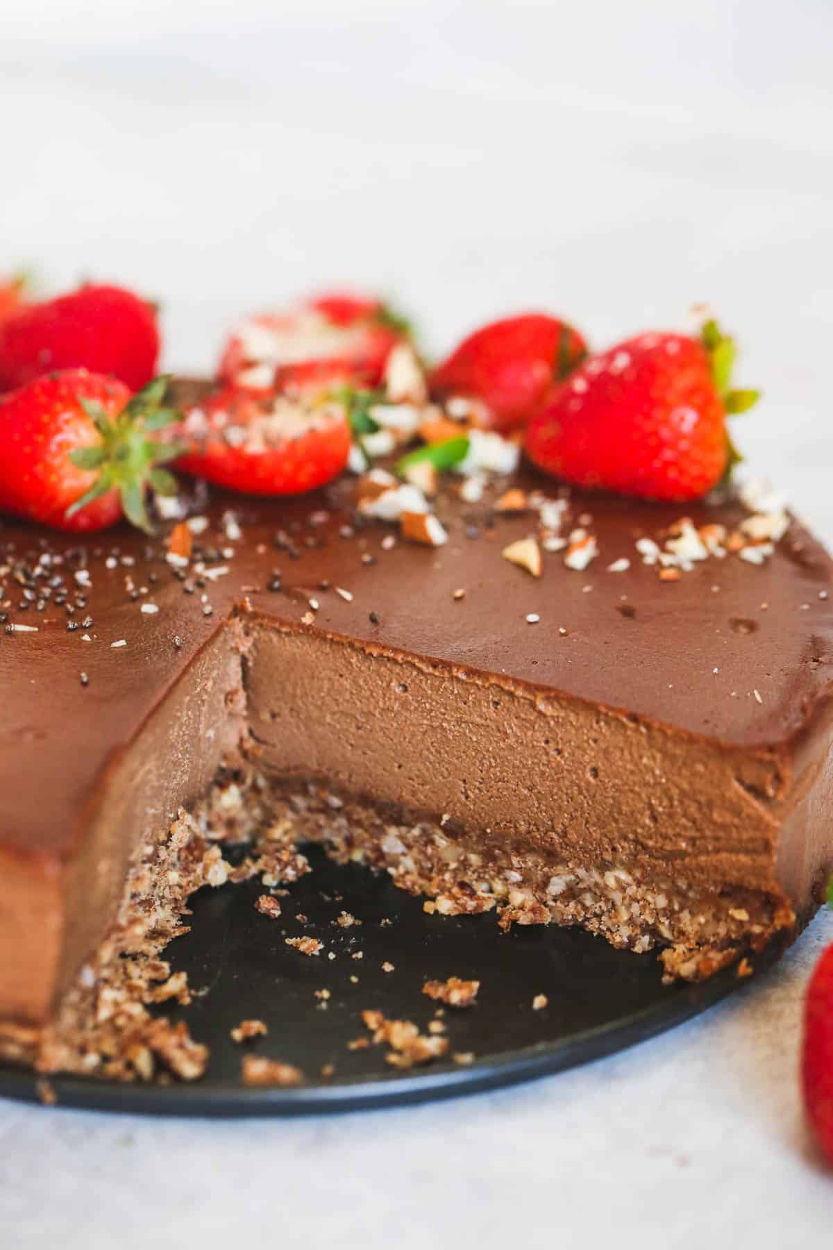 A thick chocolate cheesecake topped with strawberries.