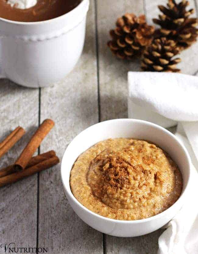 A bowl of snickerdoodle dip with cinnamon sticks next to it.