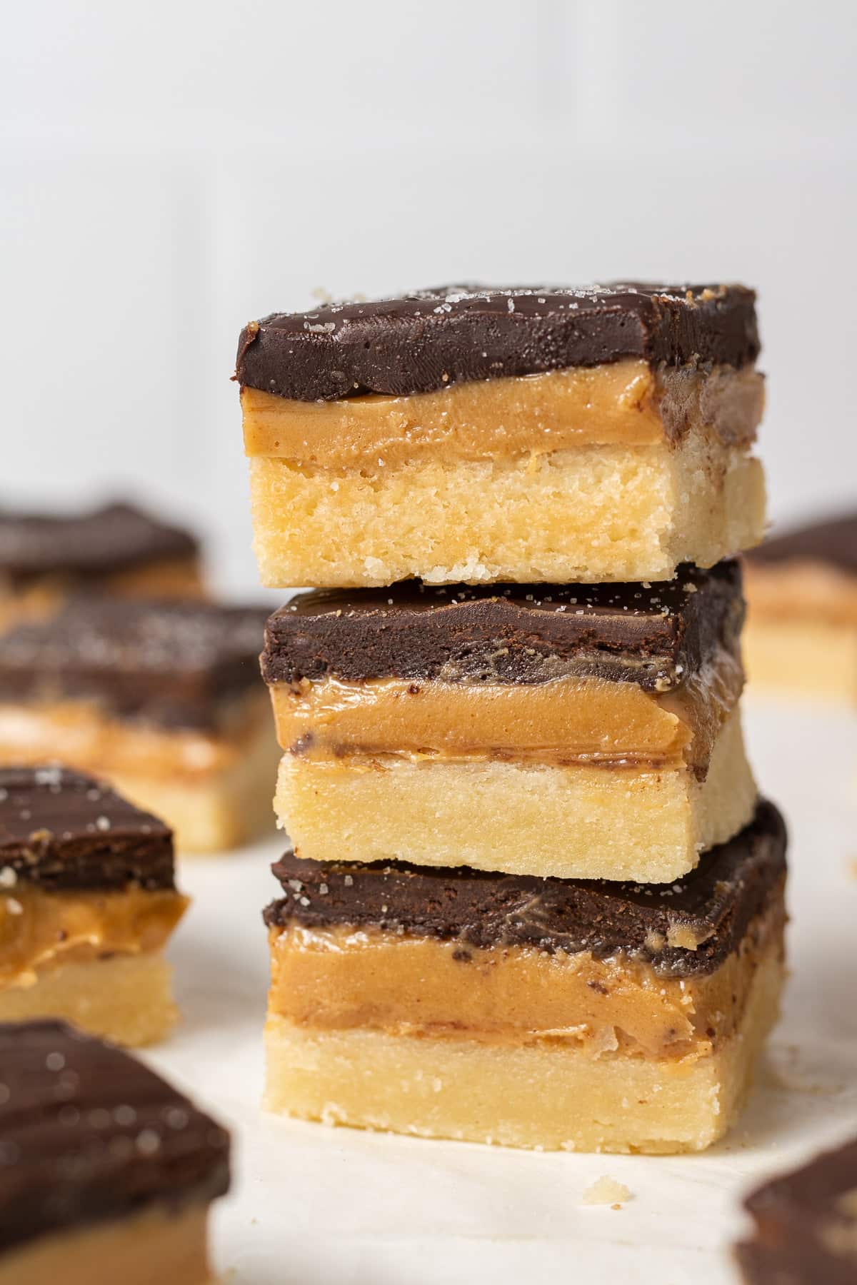 A stack of millionaire's shortbread bars each topped with a chocolate layer.