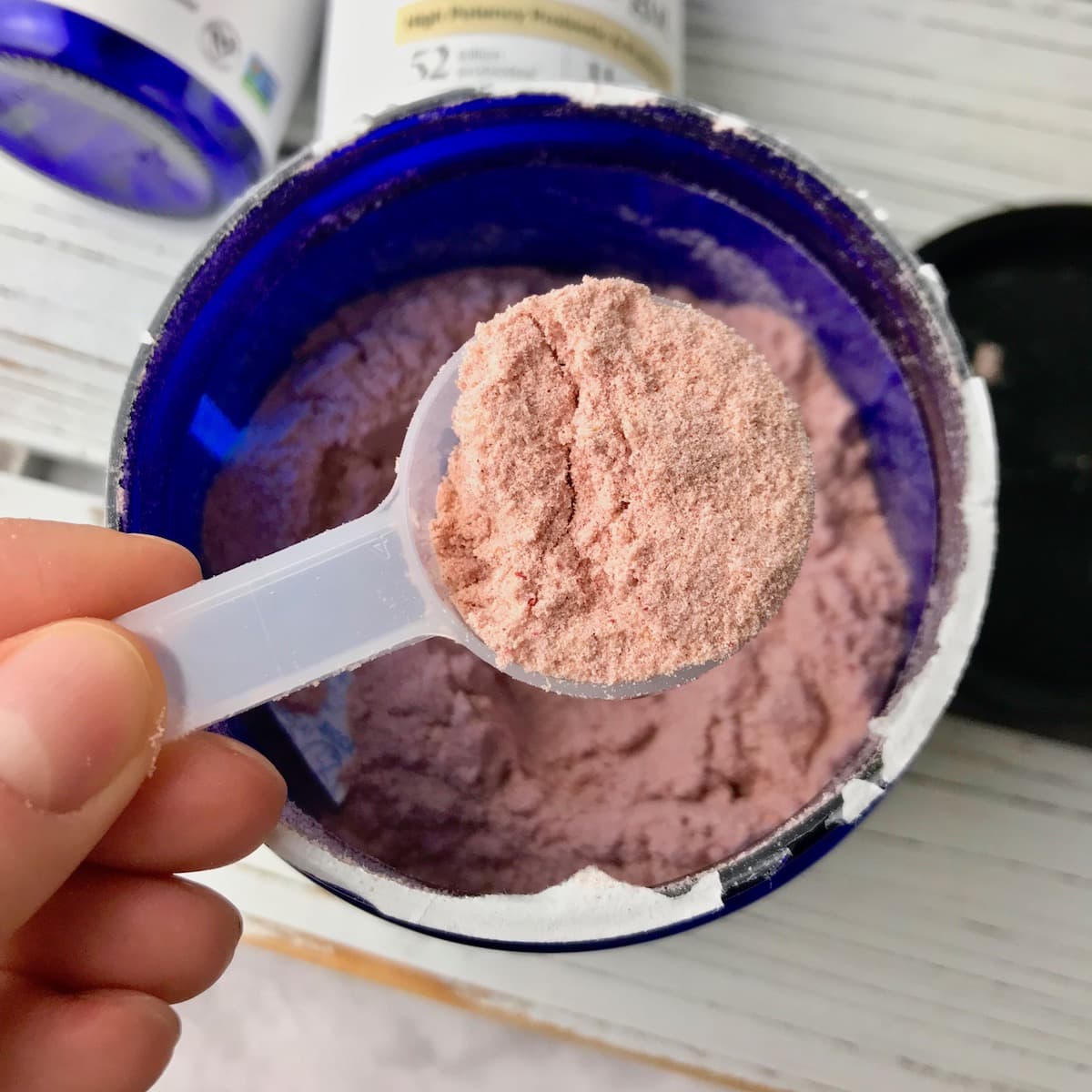 A scoop of pink vegan probiotic powder.